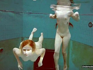Zwei atemberaubende Mädchen schwimmen im Pool und spielen mit ihren Körpern
