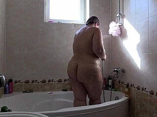 Bella donna grassa amatoriale si bagna e diventa selvaggia nel bagno con la schiuma saponica